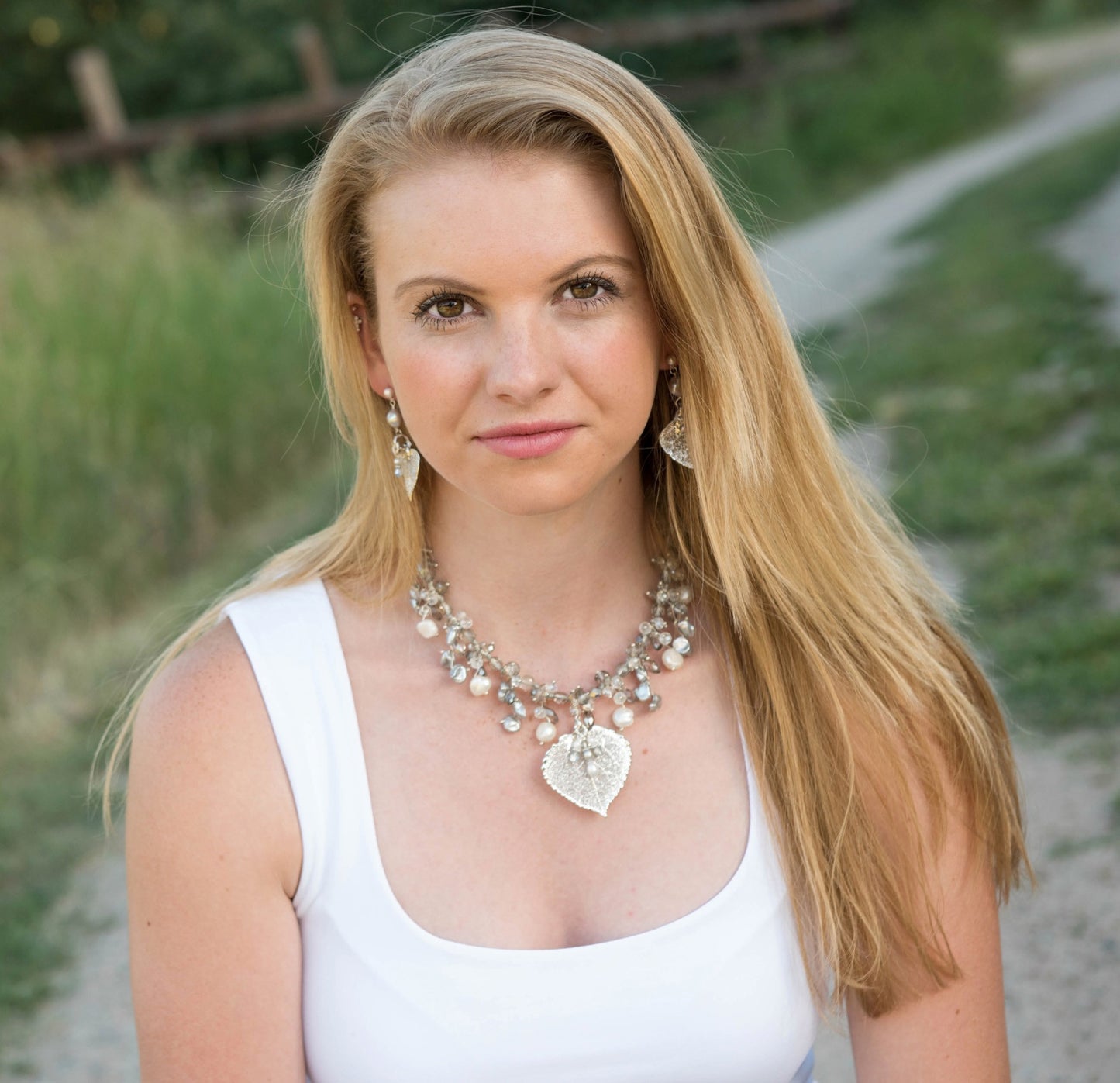 Elegant silver and white pearls are woven into this exquisite necklace with crystals and a silver Aspen leaf. A pearl & Chrystal dangle completes the piece