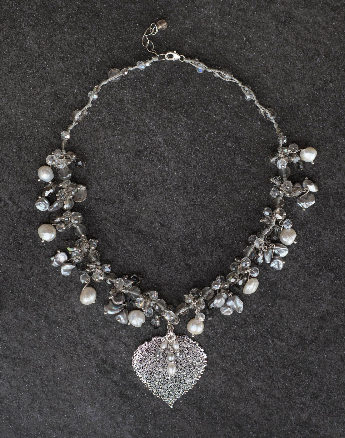 Elegant silver and white pearls are woven into this exquisite necklace with crystals and a silver Aspen leaf. A pearl & Chrystal dangle completes the piece