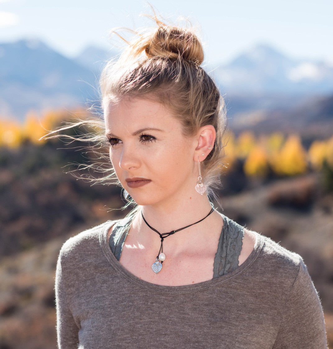 Four pearls choker: Three white baroque pearls wire twisted with a small gold leaf and back white pearl, black leather cord.