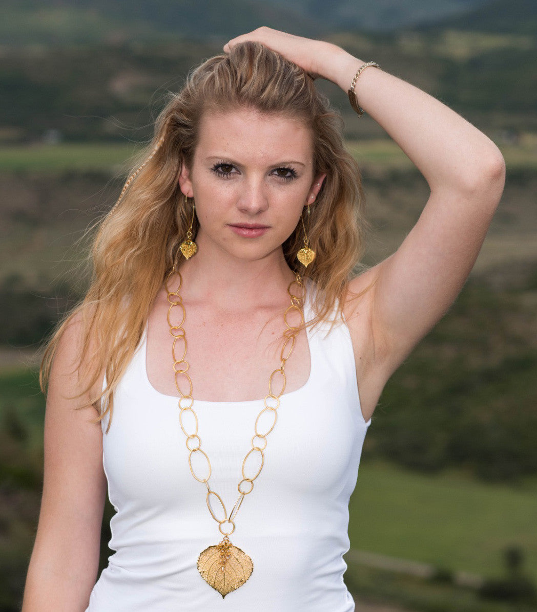 Signature gold chain combined with a large gold leaf and crystal dangles creates this striking necklace