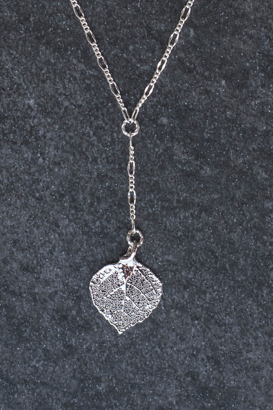 Classic silver chain creates this dramatic Y style necklace with a small Silver leaf