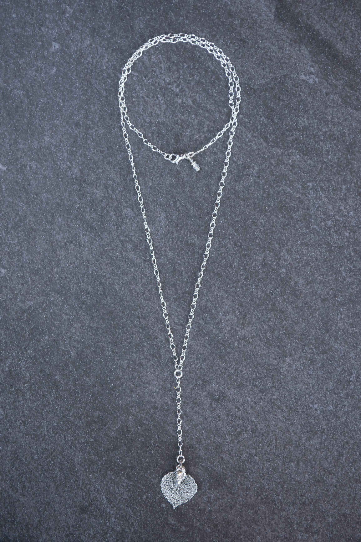 Classic silver chain creates this dramatic Y style long necklace with a small Silver leaf