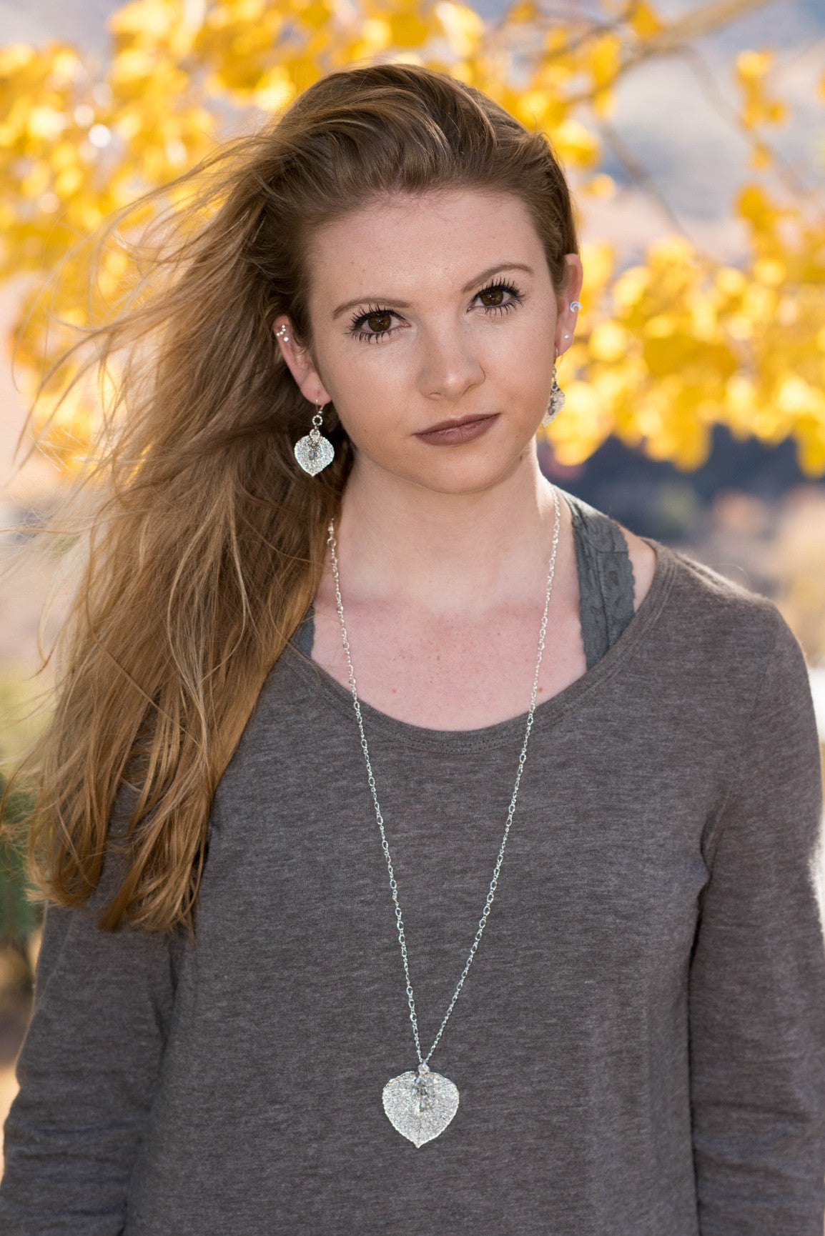 Classic silver chain creates this striking long necklace with a Silver leaf and crystal dangles