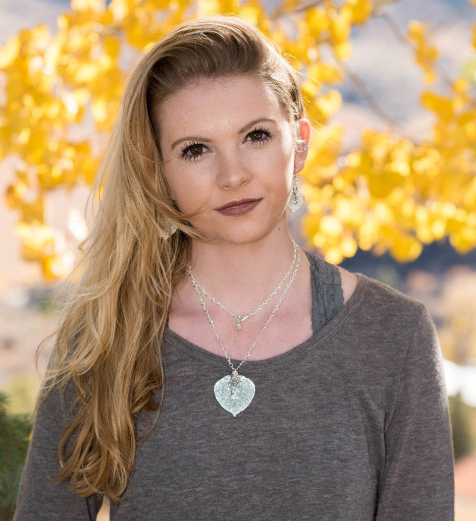 Classic silver chain creates this striking long necklace with a Silver leaf and crystal dangles