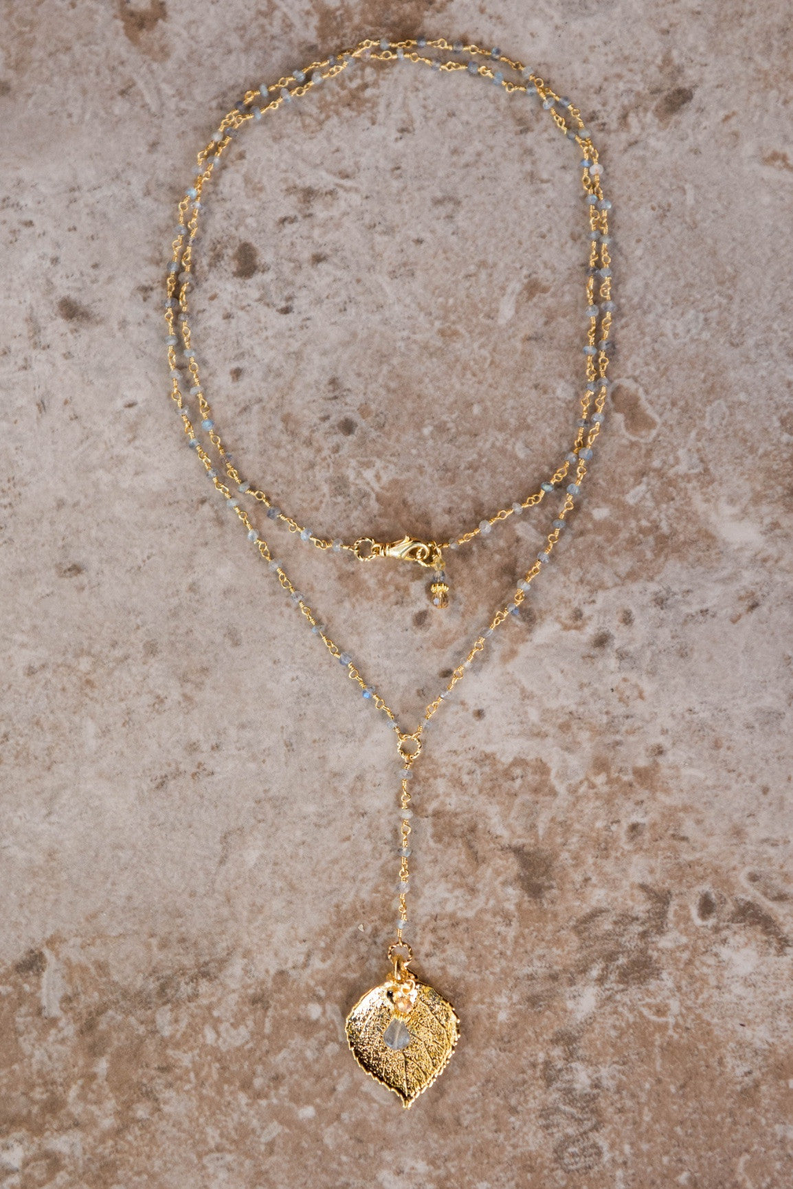 Gems in gold chain: Labradorite gems accent this dramatic Y shaped long necklace with a small gold leaf and Labradorite dangle