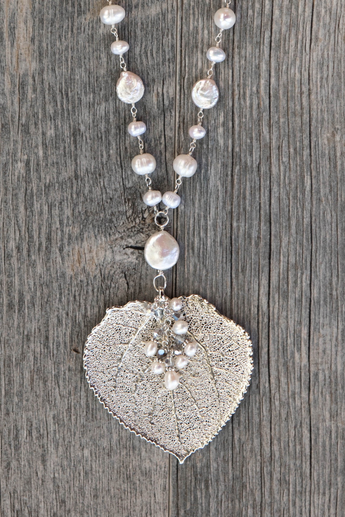 Wire twisted silver combine long strands of white freshwater & coin pearls finished with a Silver Aspen leaf & pearl dangle.