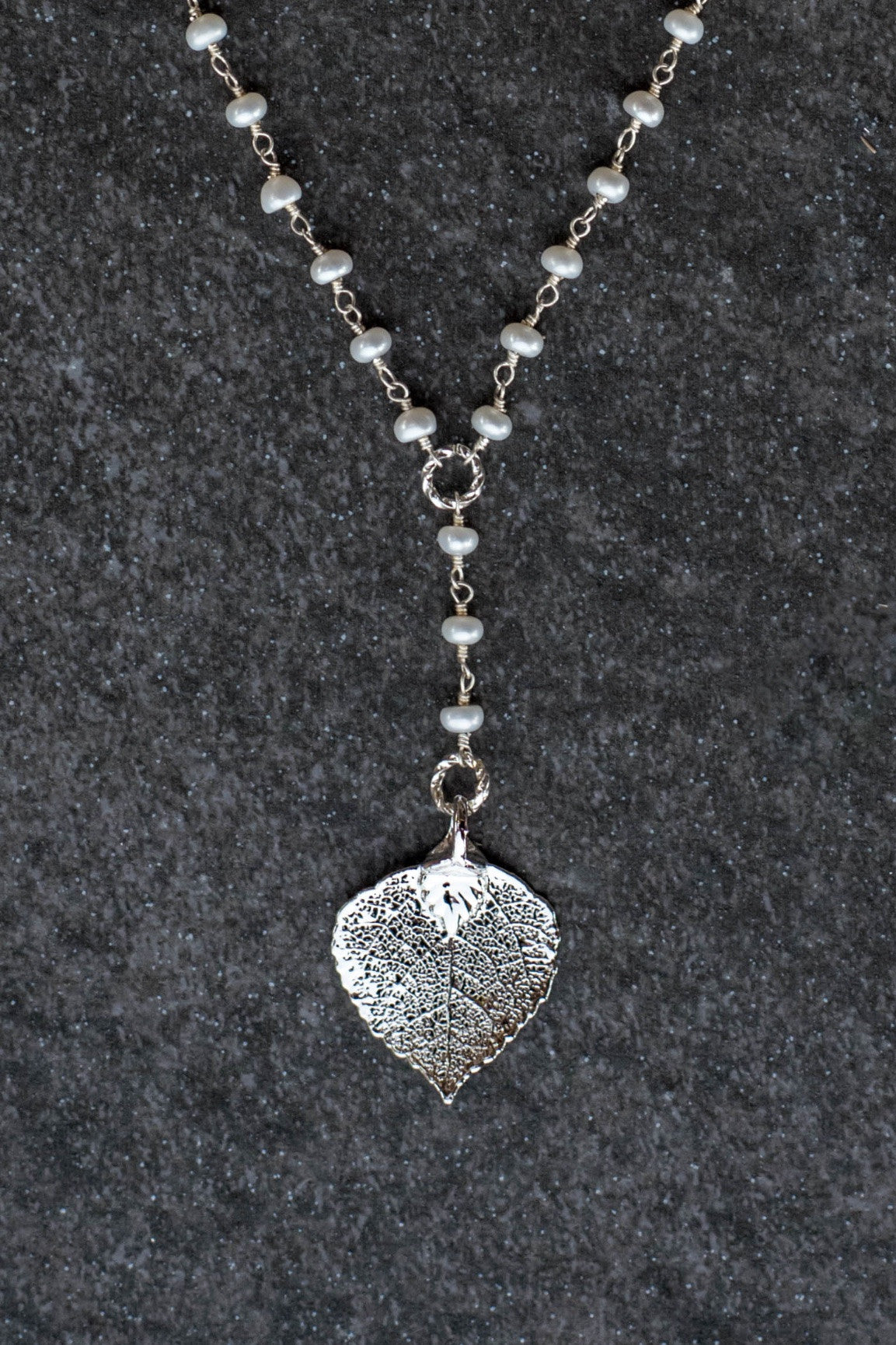 Pearls in silver chain: Fresh water pearls accent the dramatic Y style necklace with a small silver leaf