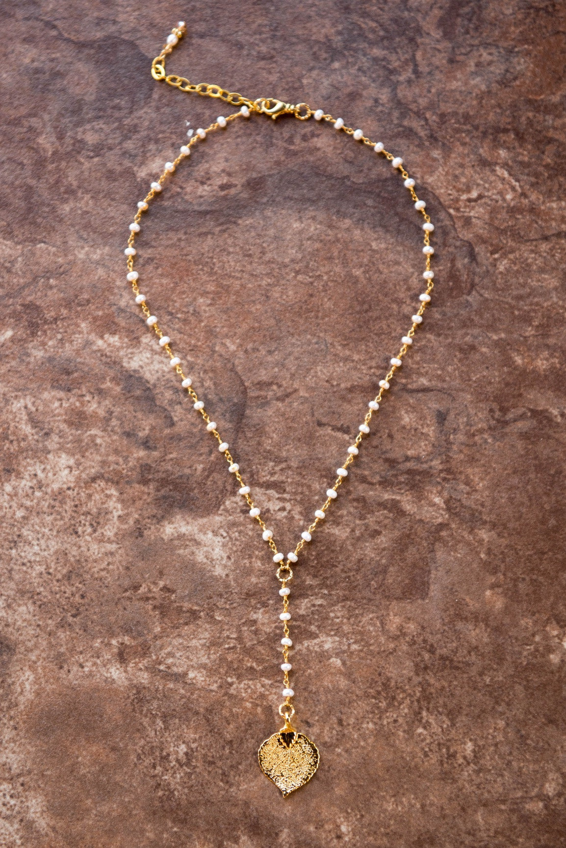 Pearls in gold chain: Fresh water pearls accent the dramatic Y style necklace with a small gold leaf