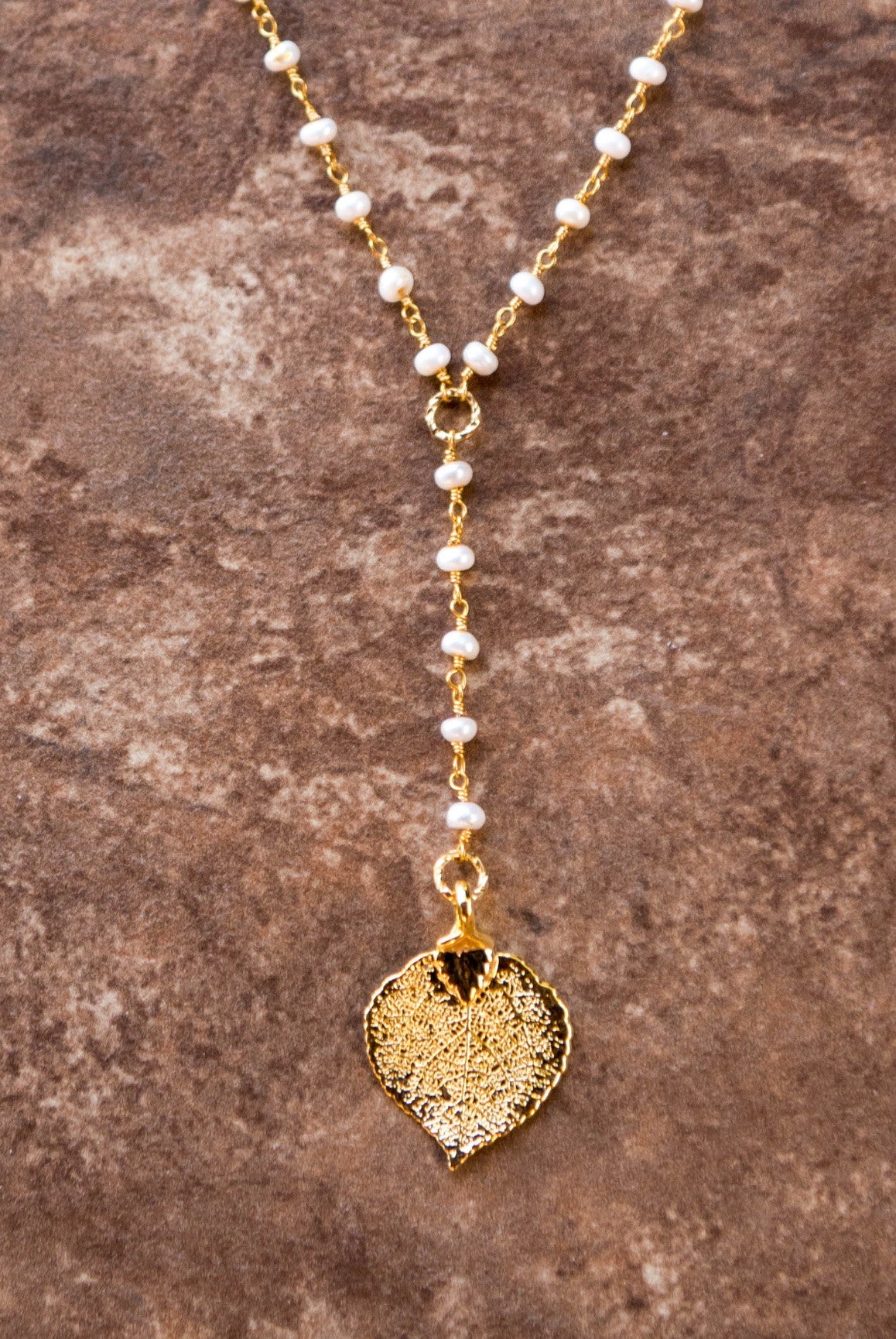 Pearls in gold chain: Fresh water pearls accent the dramatic Y style necklace with a small gold leaf