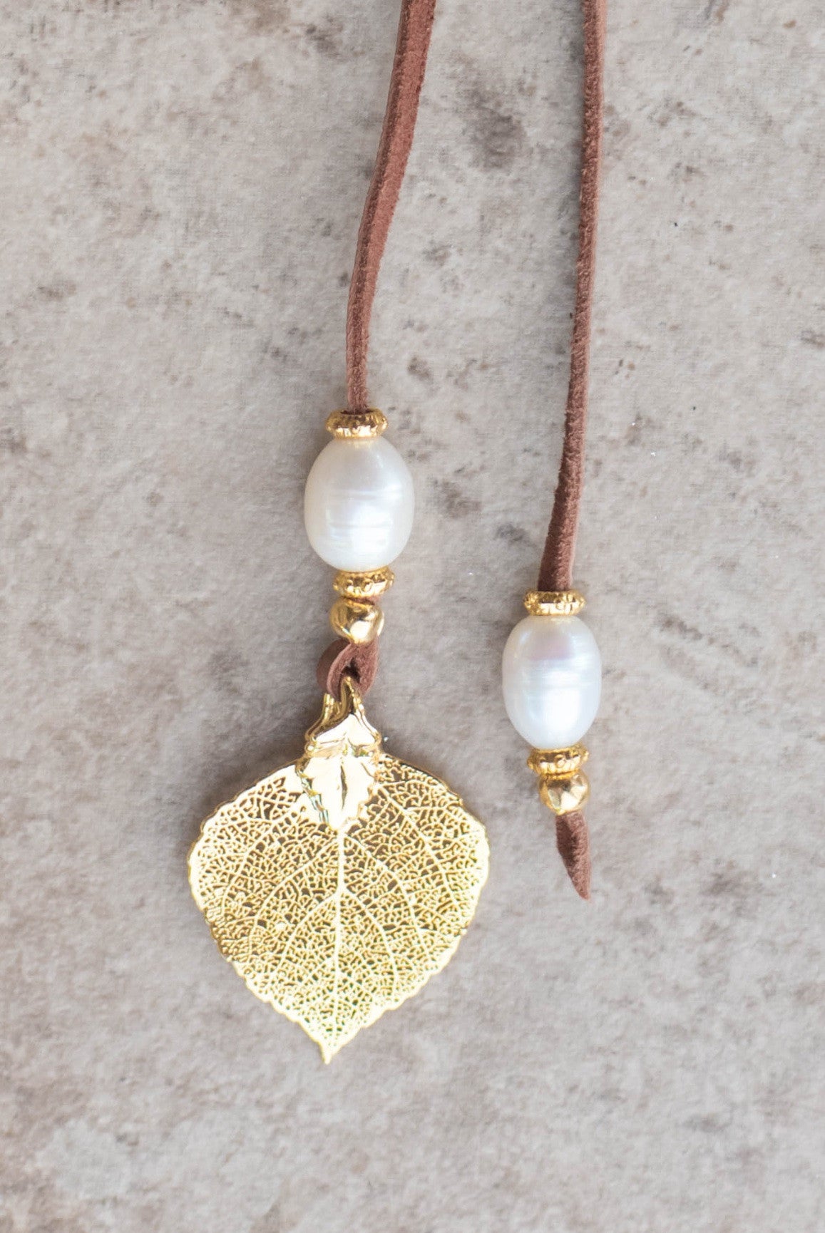 Lariat: Eight pearls highlight this versatile necklace, White freshwater pearls, gold Aspen leaf, brown  deerskin leather.