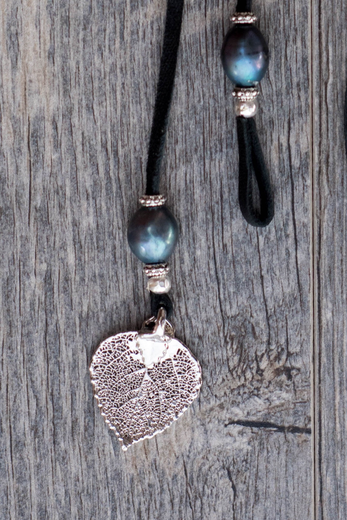 Three peacock pearls, silver leaf, black leather creates this original and trendy necklace