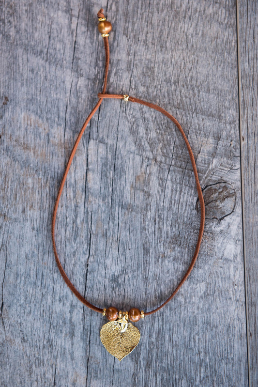 Three pearls choker: Bronze pearls with a gold leaf, come together with brown leather for this trendy versatile necklace