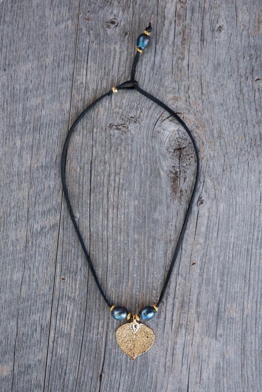 Three pearls choker: Peacock pearls with a gold leaf, come together with black leather for this trendy versatile necklace